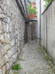 Fototapeta na wymiar narrow and deserted street in a village, Como Lake - Italy