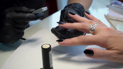 Cat's eye manicure. Nails art. Woman in a nail salon receiving a manicured by a beautician. Nails Care And Manicure. Beautiful Nail Art Manicure. Nail designs with decoration.Manicure nail paint.