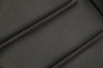 Part of leather car headrest seat details. Сlose-up gray  perforated leather car seat. Skin texture