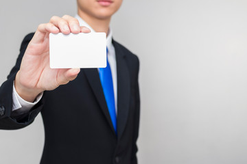 Business people show white card in his hand. Man wearing a black suit. There is copy space on the right.