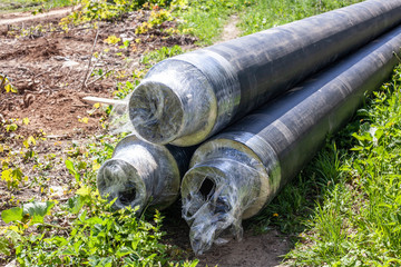 Pipes for gas. Pipes of communications lie on the ground. Repair work with laying pipes in the ground. Building material for heating.