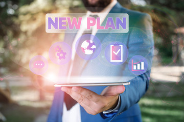 Text sign showing New Plan. Business photo showcasing Start of a detailed proposal of doing or achieving something Male human wear formal work suit presenting presentation using smart device