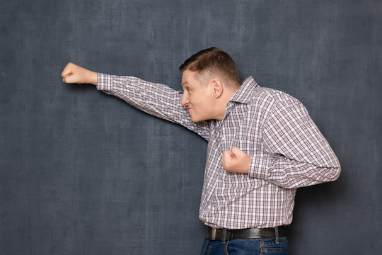 Funny awkward man is posing like brave flying superman