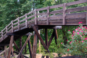 Wooden bridge over railroad tracks.