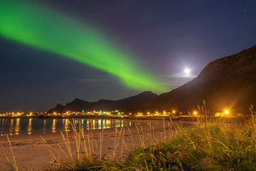 Aurora borealis over the beach and the village of Ramberg on the Lofoten Islands in Norway in Autumn