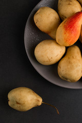 Fresh juicy appetizing pears on a gray plate, summer concept, copy space.