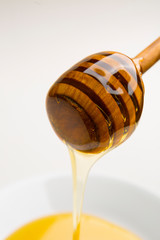 Close-Up Of Honey Dipper and honey Over White Background