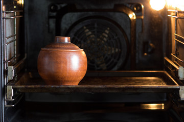 Clay pot on pan in the oven