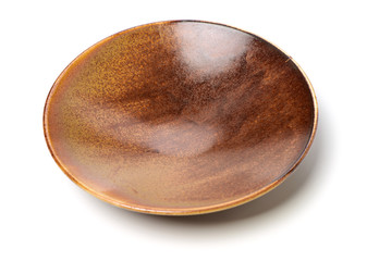 Empty brown earthenware plate on white background
