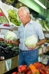 Fototapeta premium Man choosing vegetables in store