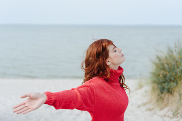 Serene young woman meditating on a beach