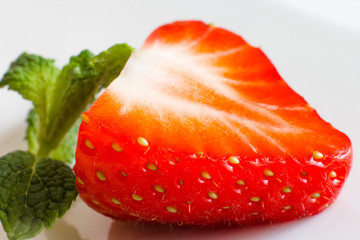 Organic fruit. Sliced half of fresh red strawberry on white background.