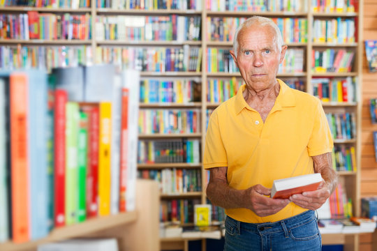 Pensive senior man standing in library