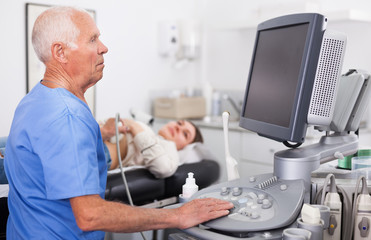 Obraz premium Skilled doctor diagnosing patient using ultrasound scanner