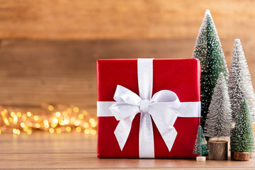 Christmas gift boxes with ribbons and tree on bokeh background.