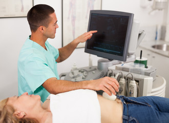Man sonographer examining female patient