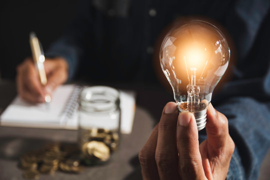 Hand Of Male Holding A Light Bulb And Copy Space For Accounting, Ideas And Creative Concept.