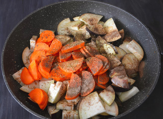 Hot spicy stewed eggplant, bell peppers and carrots in a pan.
