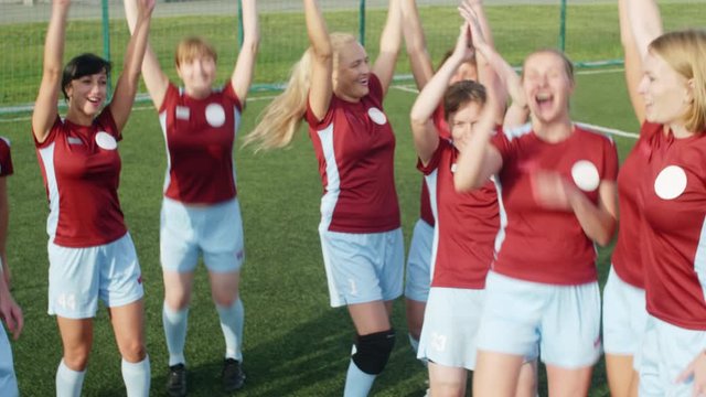High angle shot of soccer players doing hands in cheer after winning, joying and applauding each other