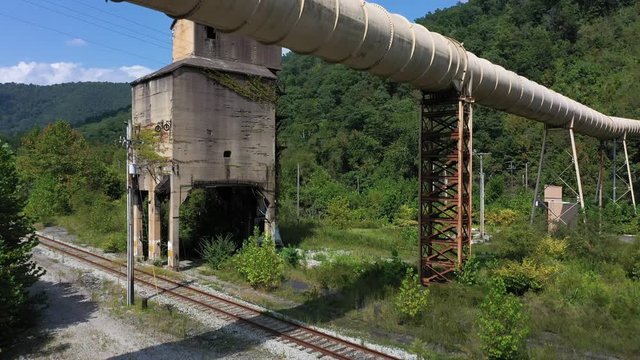 Aerial ascent showing abandoned coaling tower and newer coal slurry pipeline in Whitesville, West Virginia.