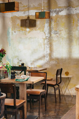 View of wooden tables set for dinner in a rustic indoors restaurant