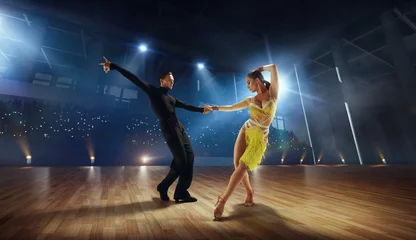 Fotobehang Couple dancers  perform latin dance on large professional stage. Ballroom dancing. © Artur Didyk