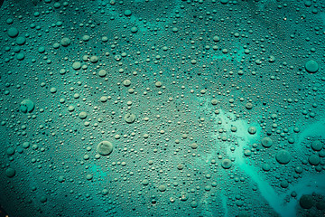 Creative abstract art background. Water drops on teal blue surface. Bubbled texture effect.