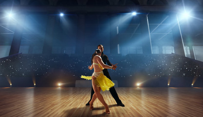 Couple dancers  perform latin dance on large professional stage. Ballroom dancing.