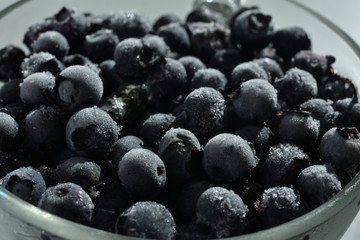 blueberries in a glass cup on white background.
