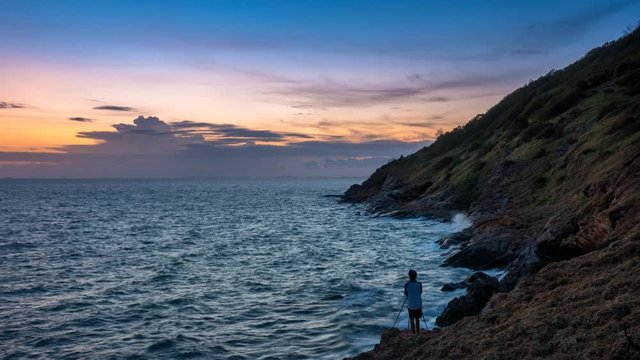 time lapse of photographer travel as back packer hiking on top of mountain at sea and ocean in sunset time near mountain and cliff in Thailand