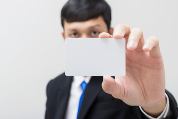 Business people show white card in his hand. Man wearing a black suit.