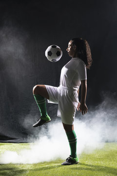 Adult fit woman playing with football