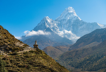 The Buddhist stupa at the edge of the mountain with beautiful with of Mt.Ama Dablam one of the most beautiful mountain in the World. View on the way to Everest Base Camp, Nepal.  - obrazy, fototapety, plakaty