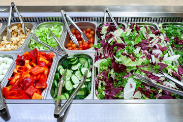 Fresh salad bar with various fresh assortment of ingredients. Display space of options for choice...