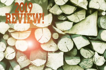 Text sign showing 2019 Review. Business photo showcasing remembering past year events main actions or good shows Background dry chopped firewood logs stacked up in a pile winter chimney