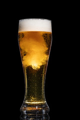 Glass of beer isolated on black background.