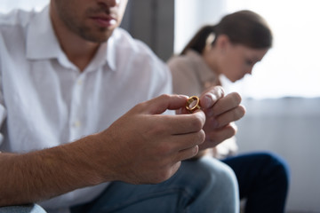 cropped view of man holding ring in hands at home