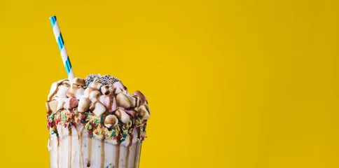 Küchenrückwand glas motiv Close-up view of delicious milkshake with yellow background © Freepik
