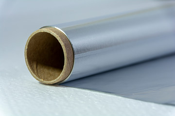 Close-up aluminum foil for baking and baking. Food foil roll, side view. Wrapping food foil on a...