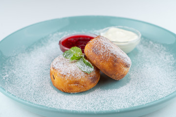 Cottage cheese pancakes with sour cream and berry jam isolated on white flat lay