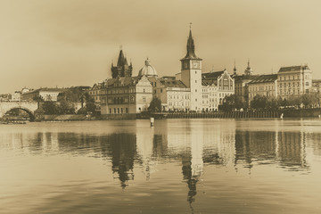 Obraz premium Prague Old Town on the banks of Vltava river, scenic cityscape with reflection in the water, Czech Republic. Old vintage film style image