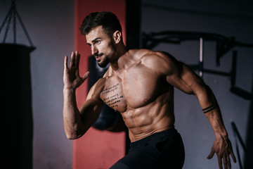 Fototapeta na wymiar Attractive fit body guy take the ruby poses then start to run in a cross fitness class he doing a intense workout training