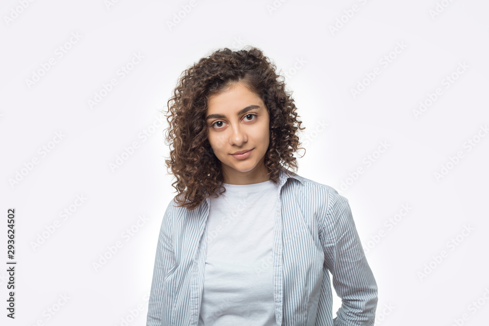 Wall mural portrait of an attractive indian young woman on a white background. a mixed race girl is looking at 