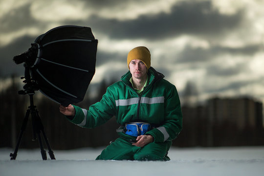 The photographer takes autoportrait remotely on the meadow. Outside.