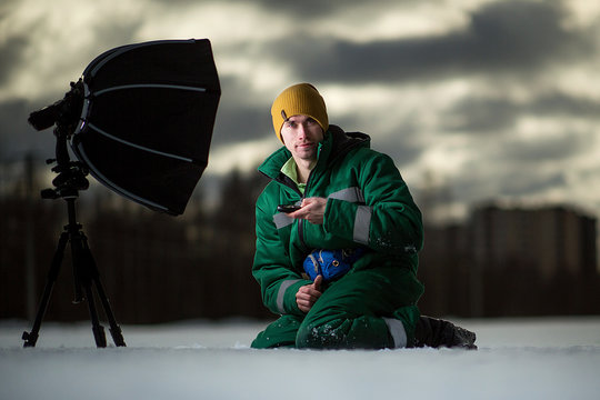 The photographer takes autoportrait remotely on the meadow. Outside.