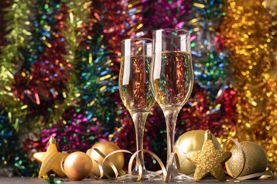 Champagne in glass goblets Christmas toys serpentine stars a sparkling festive background. New year christmas concept.