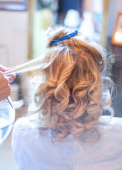 Eine Frau bekommt beim Frisör die Haare gemacht