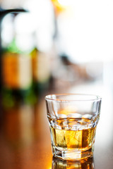Glass of whiskey on the rocks  in shallow focus