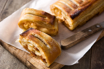 Traditional homemade apple strudel on brown background