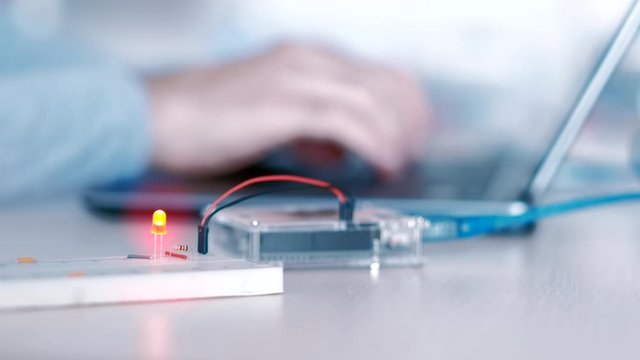 Automation technology. Robotics engineering. IT developer building electronics project with microcontroller. Blur background.